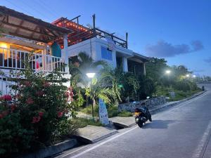 uma moto estacionada numa rua ao lado de uma casa em Posada Sunrise View em Providencia