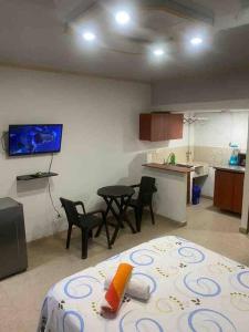 Pokój z łóżkiem oraz kuchnią ze stołem i krzesłami w obiekcie Apartaestudio privado con aire cerca Aeropuerto w mieście Cali