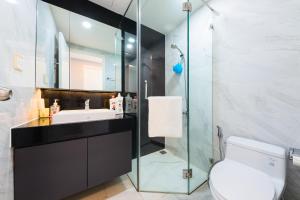 a bathroom with a toilet and a glass shower at Elysium CBD Rivergate Apartment - Gym & Pool - Free 4G sim for 3 nights in Ho Chi Minh City