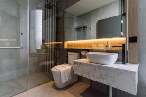 uma casa de banho com um lavatório, um WC e um chuveiro em Impiana by Roxy Hotel em Kuching mais 32 fotografias