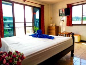 a bedroom with a large bed with a large window at Kata Lina guesthouse in Kata Beach