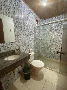 a bathroom with a toilet and a sink and a shower at Águas de Sauípe in Porto de Sauipe