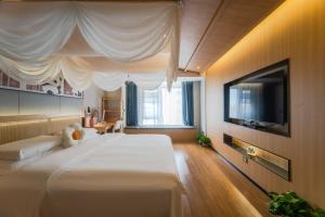 a bedroom with a large bed with a tv and a bed sidx sidx sidx sidx at AT NIGHT HOTEL Chengdu in Chengdu