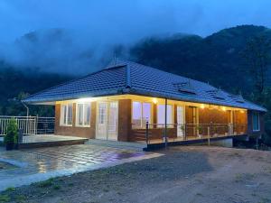 a small house with lights on the front of it at Earth Lounge Resort in Vagamon
