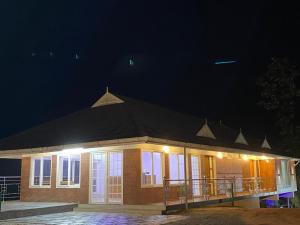 a small building with a black roof at night at Earth Lounge Resort in Vagamon