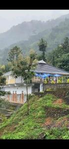 a house on top of a hill with a tree at Earth Lounge Resort in Vagamon