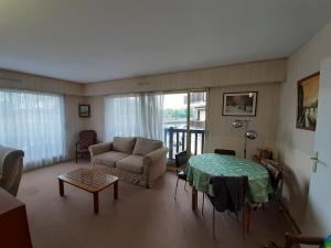 ein Wohnzimmer mit einem Sofa und einem Tisch in der Unterkunft Appartement Trouville-sur-Mer, 3 pièces, 6 personnes - FR-1-712-68 in Trouville-sur-Mer