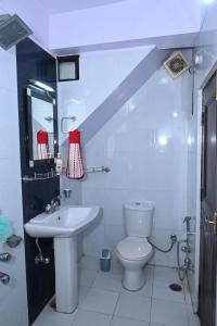 een witte badkamer met een wastafel en een toilet bij Om Niwas Homestay in Shimla
