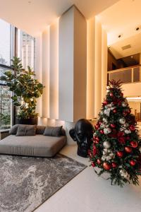um quarto com uma árvore de Natal e uma cama em Impiana by Roxy Hotel em Kuching