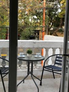 a table and chairs on a balcony with two cups at Hotel Namaste in Mendoza