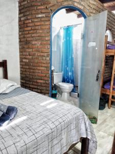 a bedroom with a bed and a bathroom with a toilet at Pousada Maravilha Itacaré in Itacaré