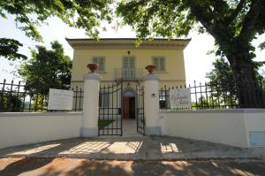 une maison blanche avec un portail et un arbre dans l'établissement La Locanda di Adele - Il Giardinetto B&B, à Scarperia