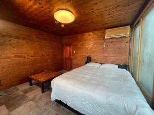 sypialnia z białym łóżkiem i drewnianą ścianą w obiekcie HOTEL1800 w mieście Seki