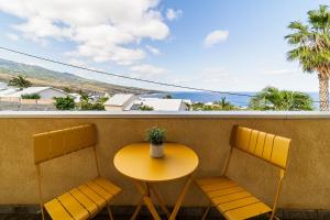 d'une table et de chaises sur un balcon avec vue sur l'océan. dans l'établissement Leu Boucan, à Saint-Leu