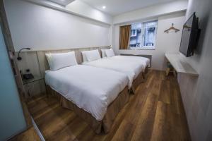 台北的住宿－雅璞文旅，酒店客房设有两张床和电视。