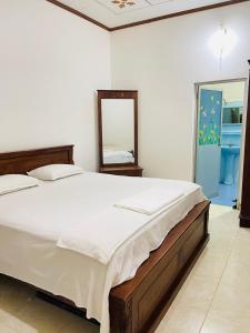 a bedroom with a large bed and a mirror at Shalomi's villa & Happy Home in Negombo