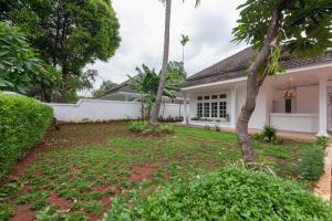 um quintal de uma casa com duas palmeiras em Urbanview Hotel De Breeze Kemang Jakarta by RedDoorz em Jakarta