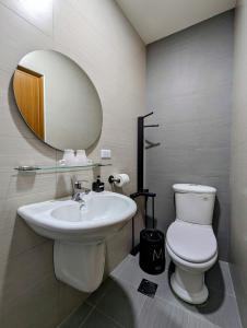a bathroom with a sink and a toilet and a mirror at 40Inn Backpackers Warehouse in Taitung City