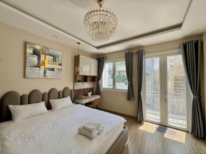 um quarto com uma cama grande e um lustre em Amazing Merit Ben Thanh em Ho Chi Minh