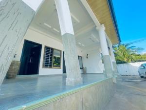 a front porch of a house with columns at Rakka Guest House in Adentan