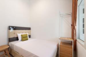 um pequeno quarto com uma cama e uma janela em Urbanview Hotel De Breeze Kemang Jakarta by RedDoorz em Jakarta
