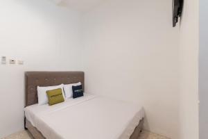 Postel nebo postele na pokoji v ubytování Urbanview Hotel De Breeze Kemang Jakarta by RedDoorz