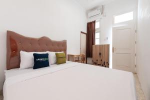 Postel nebo postele na pokoji v ubytování Urbanview Hotel De Breeze Kemang Jakarta by RedDoorz