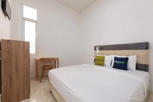 Postel nebo postele na pokoji v ubytování Urbanview Hotel De Breeze Kemang Jakarta by RedDoorz