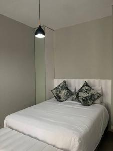 ein weißes Bett mit Kissen auf dem Zimmer in der Unterkunft 31 on Forest Road (FatsoDelux) in Johannesburg