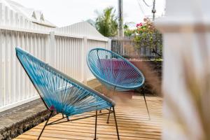 two blue chairs sitting on a deck at Leu Boucan in Saint-Leu