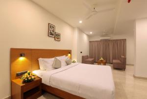 una camera con un grande letto e una sedia di HOTEL PRINCE a Kāladi