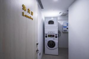 uma lavandaria com uma máquina de lavar roupa e uma placa em Apause Inn em Taipei
