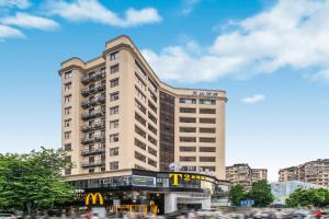 un gran edificio con un cartel de McDonalds en él en Insail Hotels (Guangyuanxincun Jingtai Pedestrian Street Guangzhou), en Guangzhou