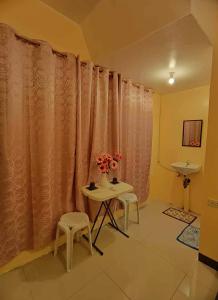 um quarto com uma mesa e cadeiras e uma cortina em CheRi Backpackers Hostel em Moalboal