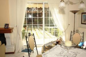 ein Wohnzimmer mit einem Tisch und einem großen Fenster in der Unterkunft House Angie in Porto Rafti