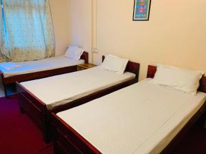 een kamer met drie bedden in een kamer bij OYO Flagship Hotel West End in Darjeeling