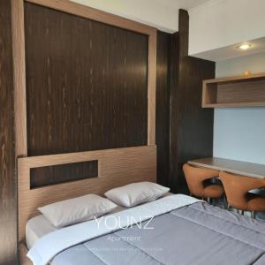 a bedroom with a bed with a wooden head board at Room Transit 3jam Apartemen Margonda Residence 2 By Younz Apartemen in Pondokcina