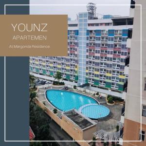 an apartment with a swimming pool in front of a building at Room Transit 3jam Apartemen Margonda Residence 2 By Younz Apartemen in Pondokcina