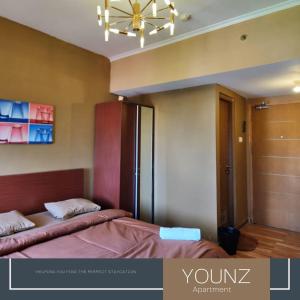 a bedroom with two beds and a chandelier at Room Transit 3jam Apartemen Margonda Residence 2 By Younz Apartemen in Pondokcina