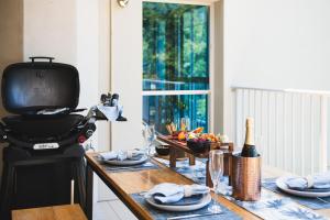 una cocina con una mesa con una parrilla encima en Picture Perfect On Azure, en Airlie Beach 17 fotos más
