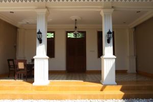 a room with two white columns and a door at Griya Hanna in Yogyakarta +3 photos