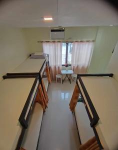 a room with two beds and a table and a window at CheRi Backpackers Hostel in Moalboal
