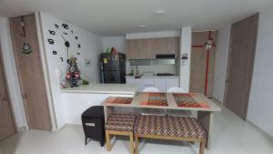 uma cozinha com uma mesa e cadeiras e um frigorífico em Apartamento en Ricaurte para descansar y disfrutar em Ricaurte