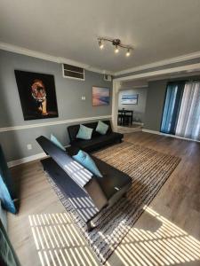 uma sala de estar com um sofá preto e almofadas azuis em Blue Shark *E1* @ Midtown Large 1BR King Suite em Houston
