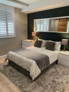 a bedroom with a large bed and a mirror at Dockside 1106 in Cape Town