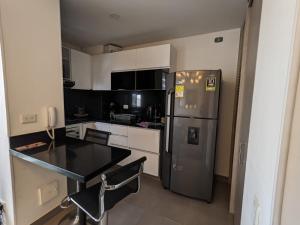 a kitchen with a stainless steel refrigerator and white cabinets at Panorama central in Bogotá