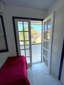 a bedroom with an open door to a balcony at Suites Brothers Centro in Búzios