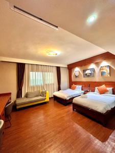 Atmosphere Hotel & Spa في أنتاناناريفو: غرفة فندقية بسريرين واريكة
