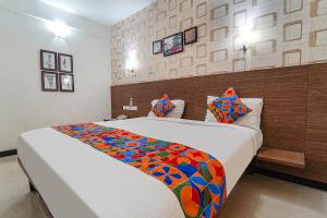 a bedroom with a large bed with a colorful blanket at FabHotel Shiva Grand in Coimbatore