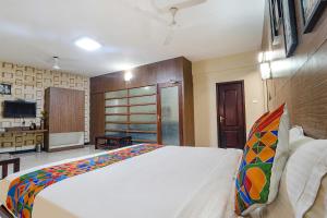 a bedroom with a large white bed and a television at FabHotel Shiva Grand in Coimbatore